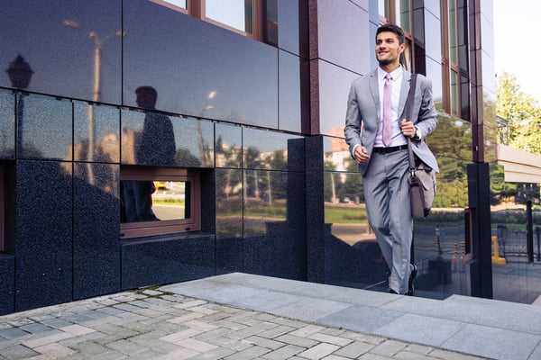 Happy businessman walking on stairs outdoors
